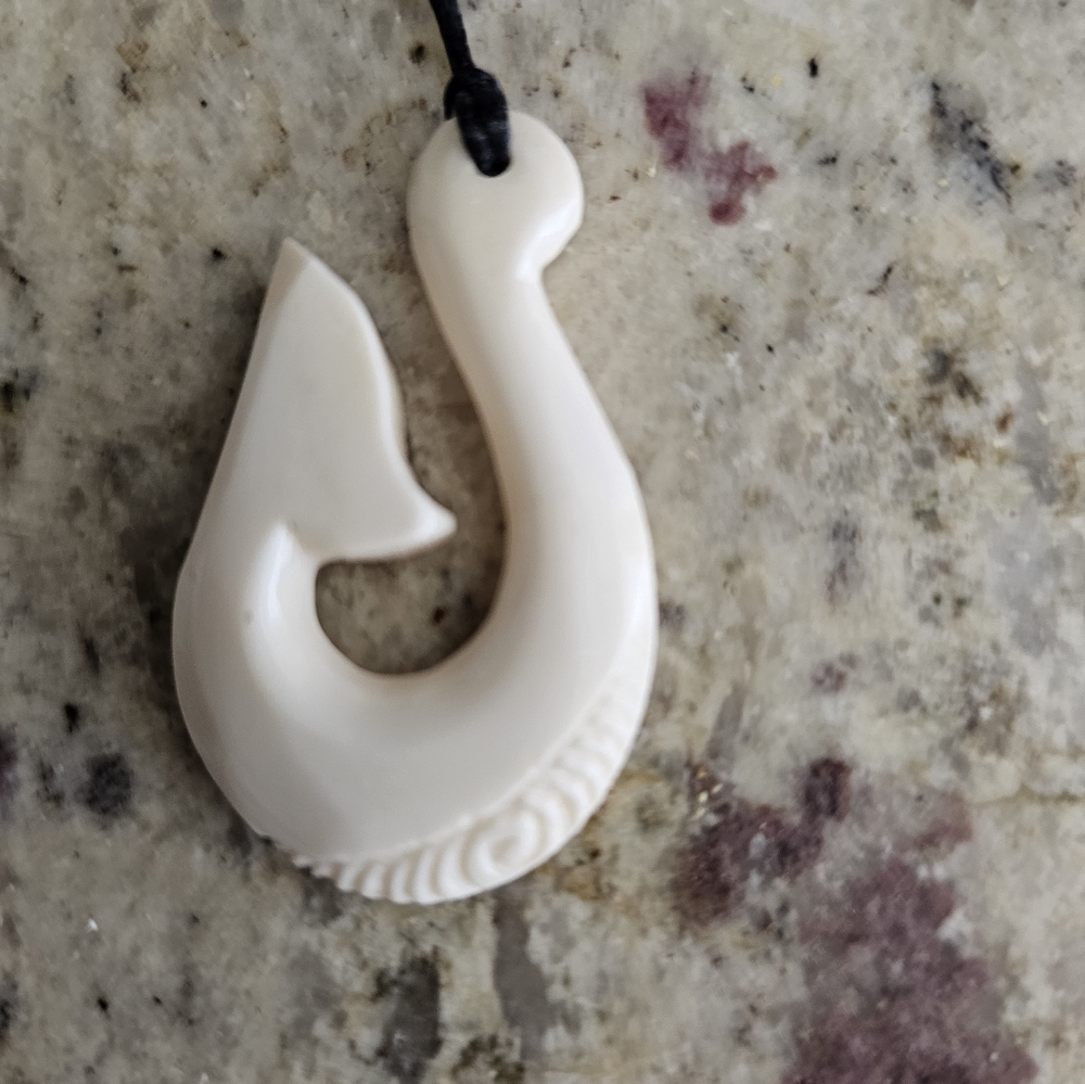 Carved New Zealand fish hook amulet